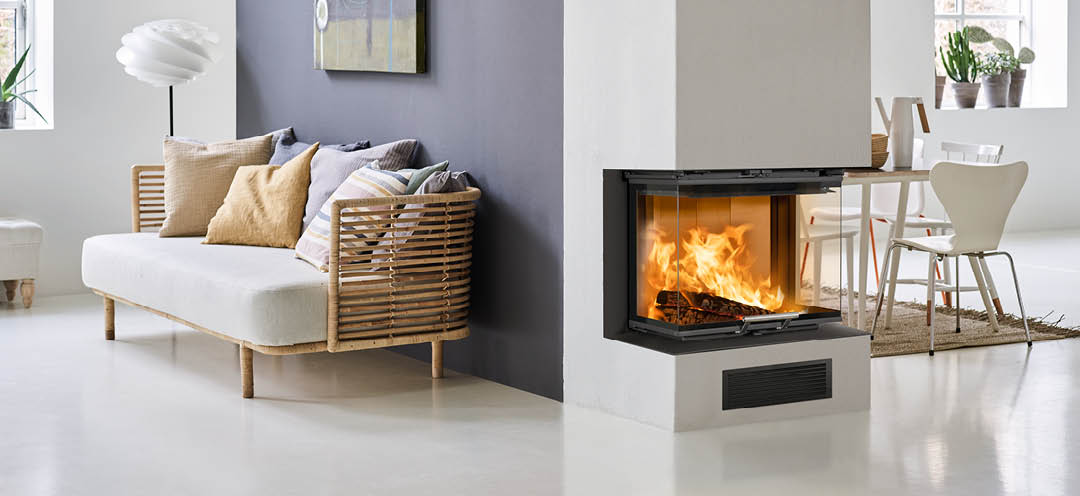 Vitt vardagsrum med bambusoffa och en lila vägg med öppen spis på gavelvägg och öppen spisinsats Scan 5004 FRL med glas på tre sidor