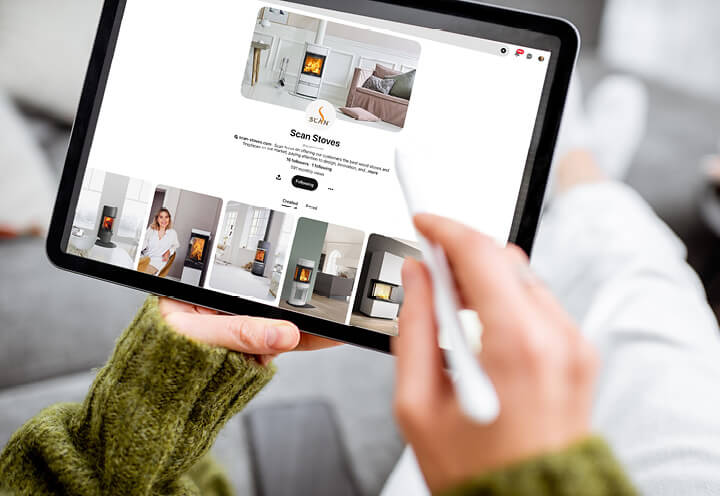 Närbild av händer som håller en surfplatta och rullar på pinterest