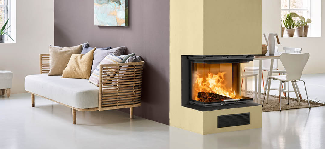 Vitt vardagsrum med bambusoffa och lila vägg med eldstad målad ljusgul på gavelväggen och spisinsats Scan 5004 FRL med glas på tre sidor