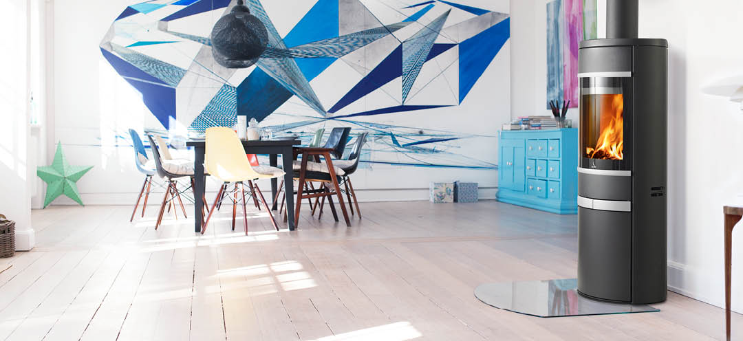 Svart oval braskamin med sidoglas, aluminiumhandtag och dekorlister Scan 68-12 i vitt vardagsrum med stor grafik ovanför matsalen