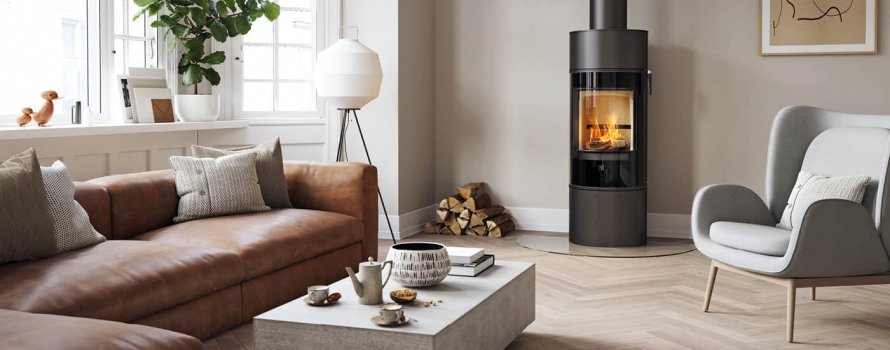 Modern braskamin Scan 84 Modern med synlig eld i ett stilrent vardagsrum med ljusa väggar, träparkett och skandinavisk inredning