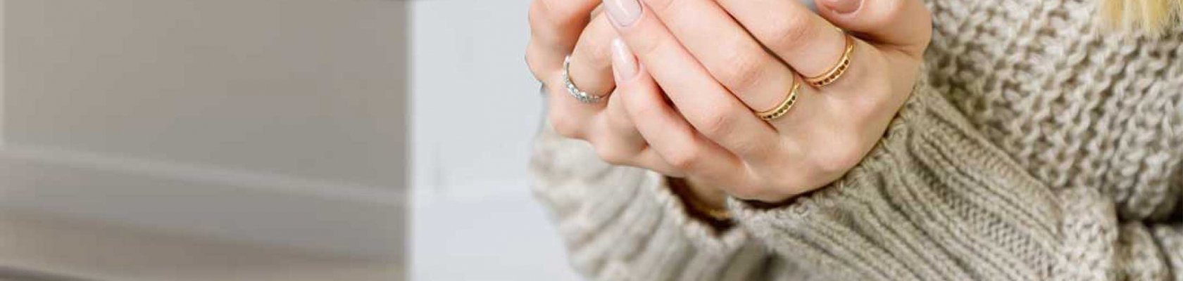 Dam med beige tröja med vit kopp med diffus öppen spis Scan 5005 FRL i bakgrunden