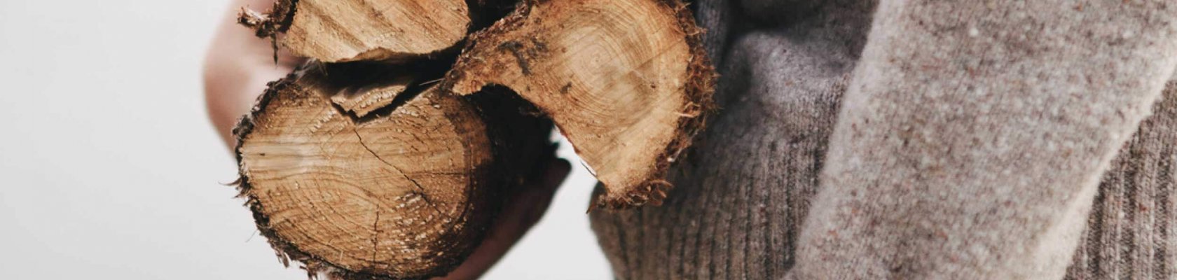 Pojke med en beige tröja som håller 3 stockar under armen