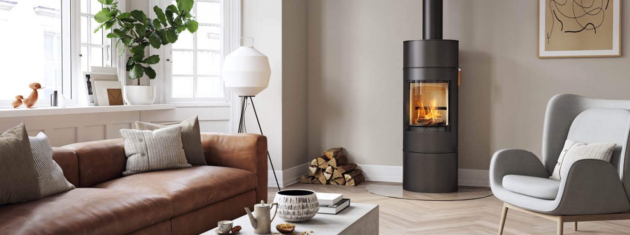 Svart Scan 84 Classic spis i ett modernt nordiskt vardagsrum med brun soffa och ljusgrå stol