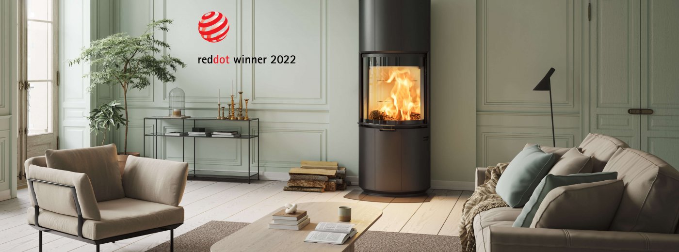 Svart öppen spis Scan 87 och stock Red Dot Award Winner 2022 i ljusgrön inredning med ljusbrun soffa och vilstol