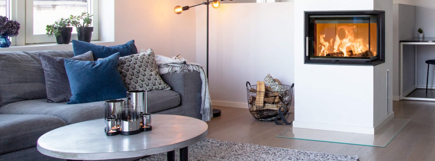 Grå sofa i moderne hvitt hjem med stor hvit peis med flammer