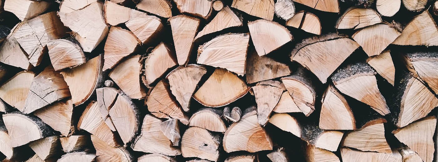 Stapel med kluvet trä i olika storlekar och färger