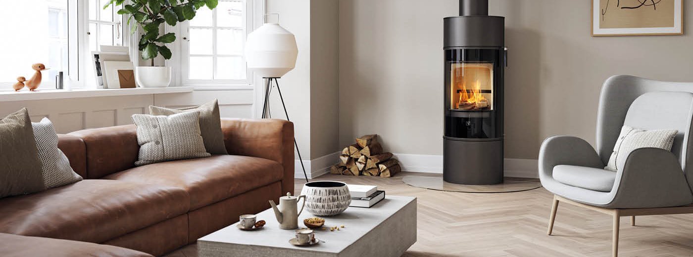 Modern braskamin Scan 84 Modern med synlig eld i ett stilrent vardagsrum med ljusa väggar, träparkett och skandinavisk inredning